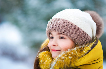 Beautiful winter portrait of a child outdoors. Face of girl close-up with snowflakes on eyelashes