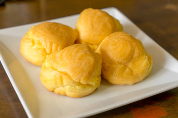 Choux cream puffs on white square plate