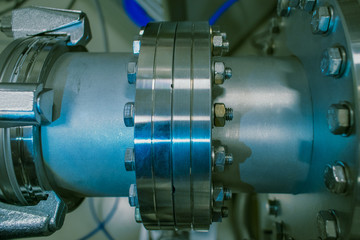 Detail of vacuum equipment featuring steel flanges and pipelines bolted to the vessel in laboratory...