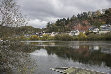 Naklejka premium Detail of Moselle river valley with typical village houses near Trier in rainy day in November, Germany. Dark autumn landscape.