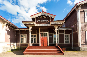 Fototapeta na wymiar Old wooden provincial railway station with platform in summer sunny day in Borovichi, Russia