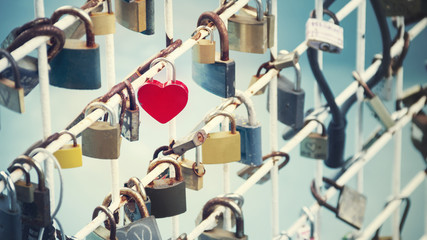 Many locks of love hanging on the railing of the bridge.