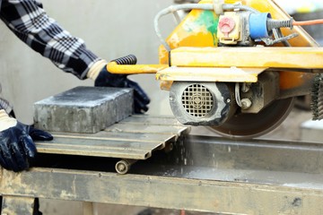 Fototapeta premium Worker on the circular tile saw