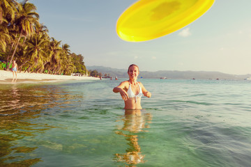 Woman plays frisbee in the water of beautiful ocean