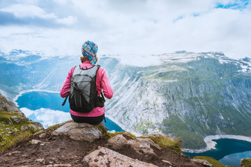 Young woman with backpack on top of fjord Norway