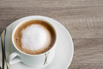 fresh hot cappuccino or mocha coffee with milk froth in white cup on wood table in the morning for breakfast drink before work on nature light at cafe coffee shop and restaurant or office with space