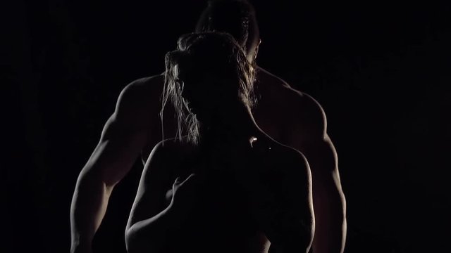 A naked woman stands against the backdrop of an inflated man and turns to him