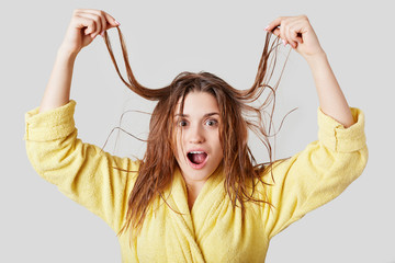 Shocked young female has unmanageable hair after taking shower, doesn`t know what hairstyle to...