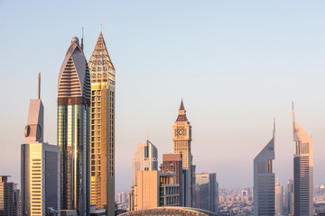 The skyline of Dubai DIFC district during a colorful sunset as viewed from a rooftop. Dubai, UAE.