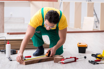 Contractor working on laminate wooden floor 