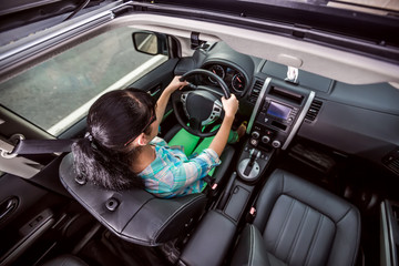 Woman behind the wheel of a car.