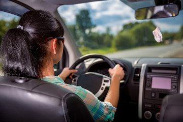 Woman behind the wheel of a car.