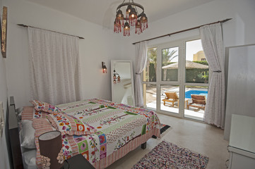 Interior design of bedroom in luxury villa with garden view