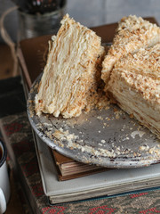 cake - Napoleon (cake with white cream is layered) and photos on a wooden table