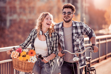 Young couple going for a bike ride on a sunny day in the city.