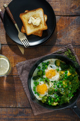 Full breakfast table. Fried eggs with vegetables in frying pan