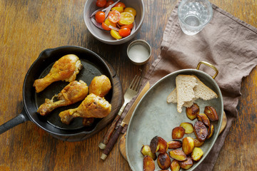 Top view Dinner table. Fried chicken legs pan potatoes salad