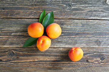 Bright ripe apricots lie on a wooden table