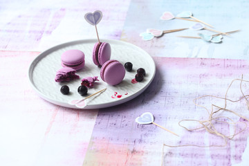 Purple Macarons with Chocolate Black Currant Filling, on grey plate, on light background.