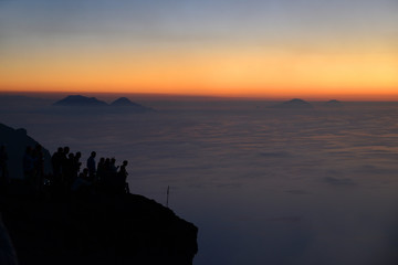 Pleople on the summit of Volcano Stromboli enjoying the sunset and view of the Aeolian Islands,...