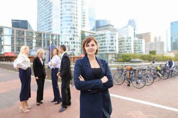 Gladden businesswoman looking at camera with close up face and smiling in La Defense Paris. Concept...