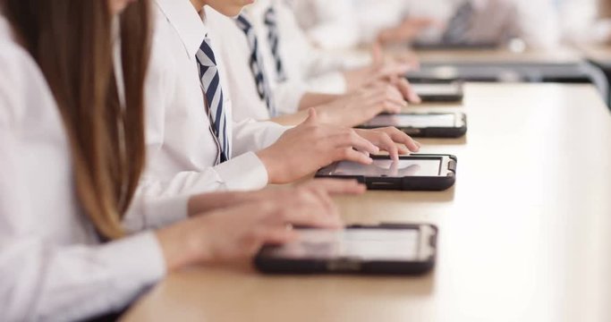 4k, Secondary school students using digital touchscreen tablet in a classroom.