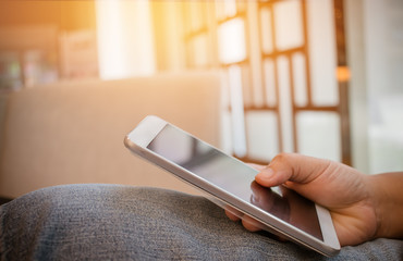 Online searching social networks by Smartphone Concept: Hand of Woman pointing finger on blank screen smart phone, using hand clean gadget or typing sms message to her friends in coffeeshop background