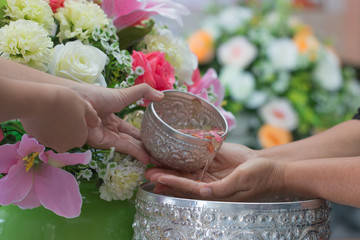 Songkran Thai festival concept : Thai people celebrate Songkran in new year water festival by giving garlands to elder seniors and asked for blessings to good life, Blur of Colorful Flowers background