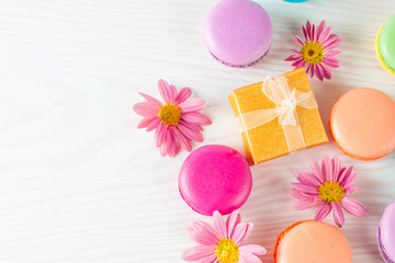 Photo of cake macarons, gift box, tea, coffee, cappuccino and flowers. Sweet romantic food macaroon concept. Morning breakfast and presents.