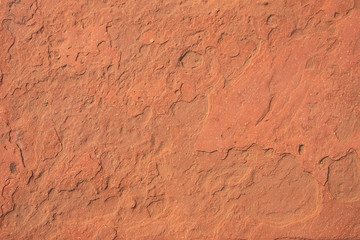 Red laterite stone surface texture background.