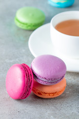 Photo of cake macarons, gift box, tea, coffee, cappuccino and flowers. Sweet romantic food macaroon concept. Morning breakfast and presents.