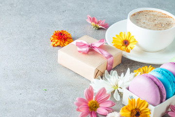 Fototapeta na wymiar Photo of cake macarons, gift box, tea, coffee, cappuccino and flowers. Sweet romantic food macaroon concept. Morning breakfast and presents.