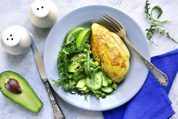Roasted chicken fillet garnished with green vegetable salad.Top view.