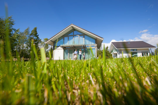 Family Running On Lawn Near House