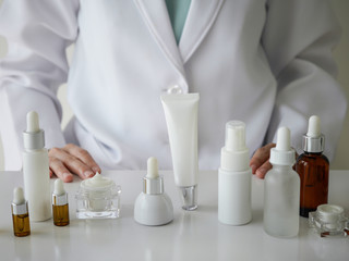 the scientist,dermatologist testing the organic natural product in the laboratory.research and development beauty skincare concept.blank package,bottle,container .cream,serum.hand