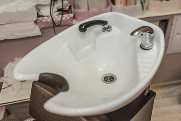 White washbasin in the hairdresser's beauty salon