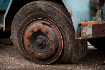 Old ruined truck tire, flat tire on rusted wheel