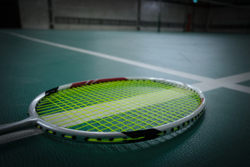 Badminton racket on badminton court With white lines