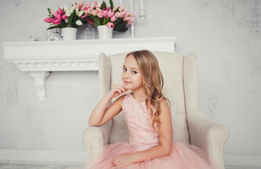 Beautiful little girl in charming dress sitting on the armchair © jozzeppe777