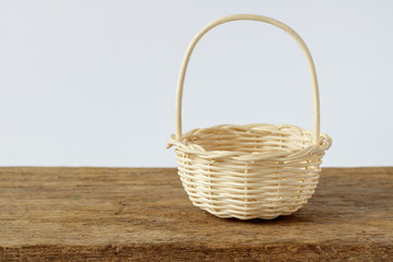 Wood woven basket isolated on wooden table and white background.