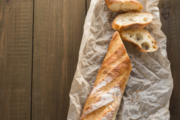 A baguette on a wooden background.
