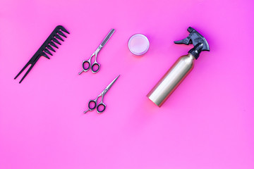 Professional tools for haircut. Sciccors, comb, spray on pink background top view copy space