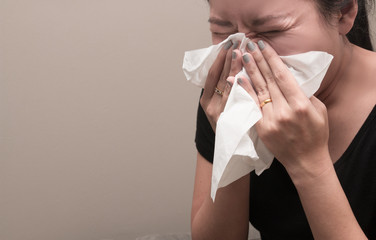 Asian woman holding tissue paper blowing nose, Flu concept