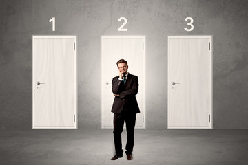 Fototapeta premium Businessman thinking in front of three doors
