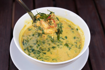 Spicy Curry crab with Piper sarmentosum in bowl on wooden table