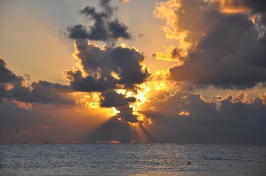 Sunrise over the sea. The sun fights against clouds.