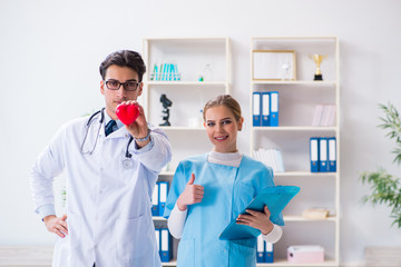 Fototapeta premium Cardiologist with his nurse assistant posing in hospital