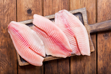 fresh fish fillet on wooden board