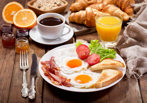 breakfast with fried eggs, coffee, juice and fresh fruits