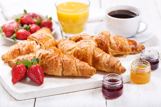 breakfast with croissants, juice, coffee and fruits